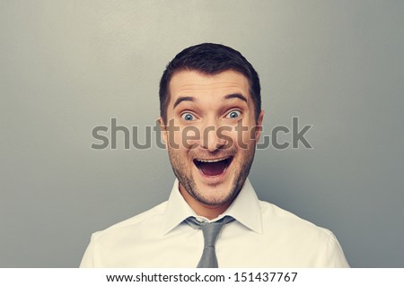 portrait of excited businessman over grey background