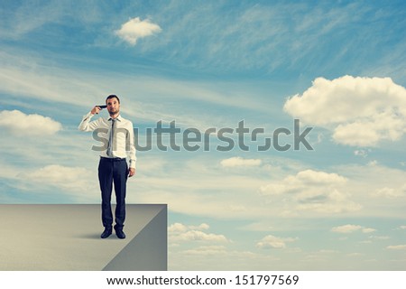 desperate businessman with gun standing on the edge