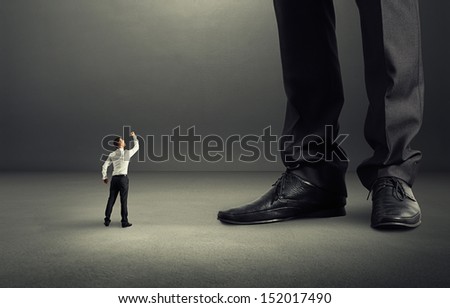 angry businessman looking up and showing fist to his big boss angry businessman looking up and showing fist to his big boss