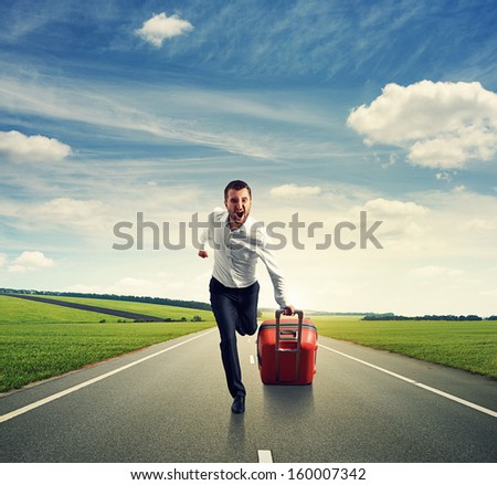 screaming man with suitcase running on the road