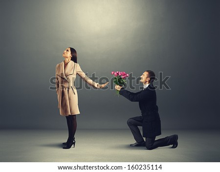 young beautiful woman don\'t looking at man with flowers
