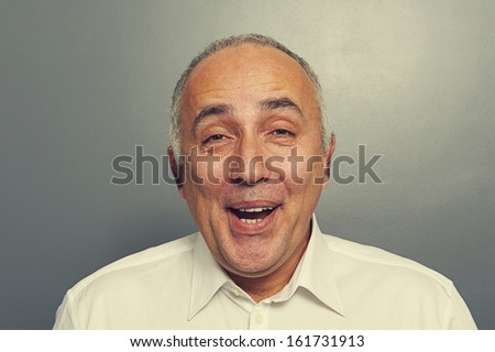 close up portrait of funny laughing man over grey background