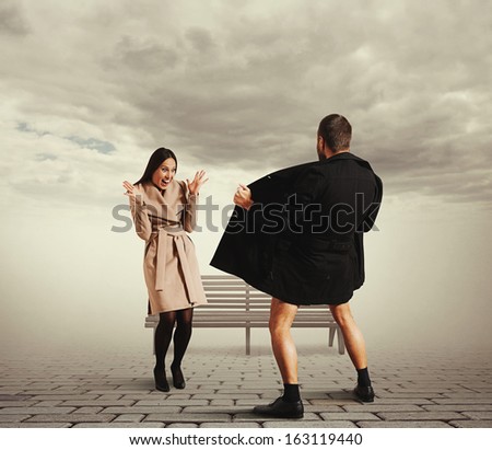 funny picture of laughing woman and exhibitionist in the park