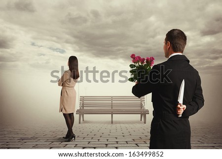 perfidious man holding flowers and knife behind back