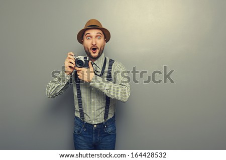 Amazed Young Man With Camera Over Grey Background