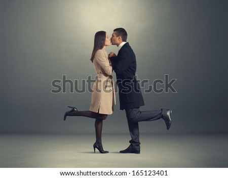 young kissing couple in love over dark background
