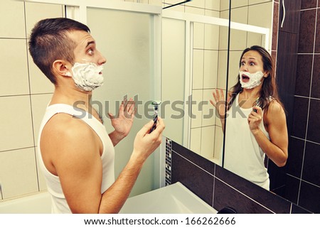amazed man shaving and looking in the mirror