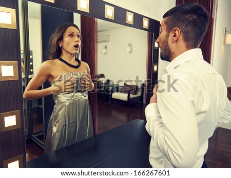 frightened man looking at woman in the mirror