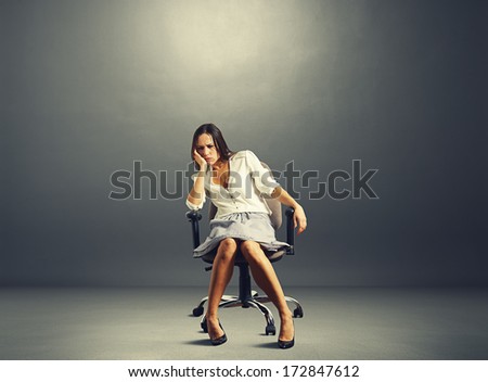 sorrowful businesswoman sitting on the chair in empty dark room