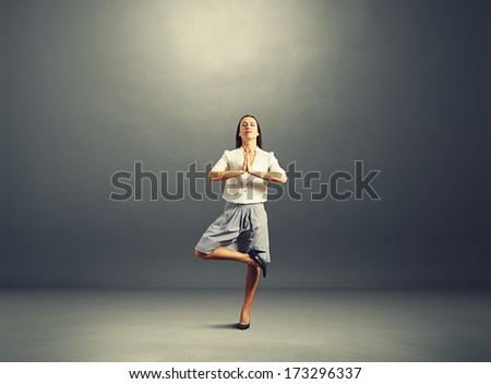 happy businesswoman practicing yoga over dark background