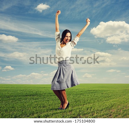 happy young woman raising hands up and laughing