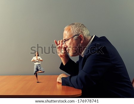 senior man looking at small meditation woman on the table