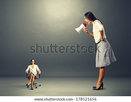 angry young woman screaming at smiley woman on the chair