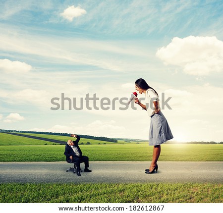 angry young woman screaming at small frightened senior man on the road