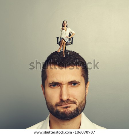 small smiley woman sitting on the displeased man and pointing