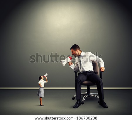 quarrel between small angry woman and big man over dark background