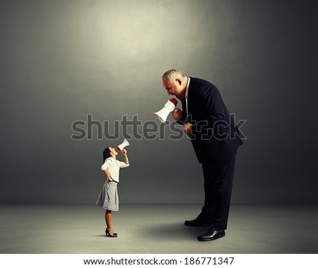 dissatisfied woman screaming at big angry man over dark background