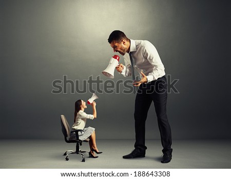 quarrel between small discontented woman and big man over dark background