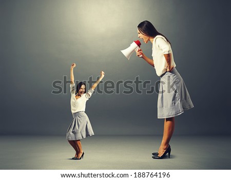 jolly woman and angry big woman over dark background