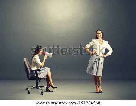 angry woman and smiley calm woman over dark background