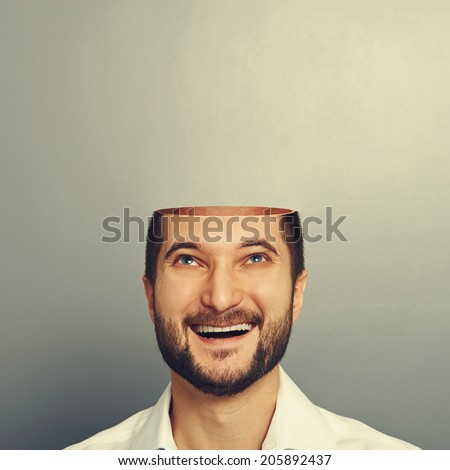 happy young businessman with open head looking up and smiling over grey background