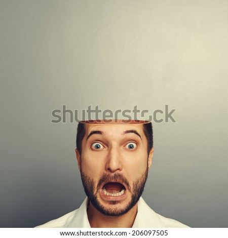 scared screaming man with open head over grey background