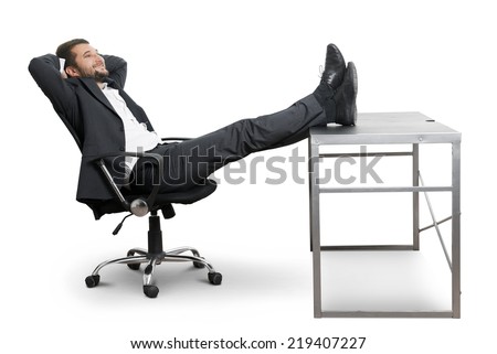 young businessman put his feet up on the table, resting and smiling. isolated on white background