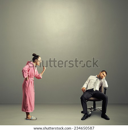 angry wife screaming at lazy husband in the grey room