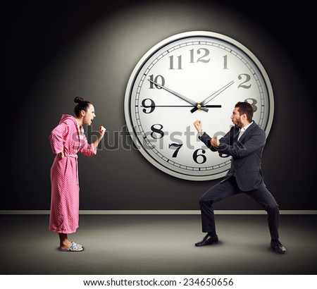 quarrel between emotional couple over wall with big clock