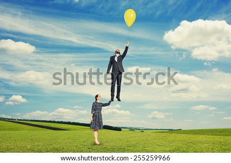 young beautiful woman holding flying man.
