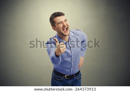 excited man screaming and showing thumbs up over dark background