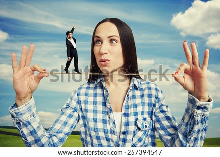 outdoor portrait of amazed woman and small man on the rope