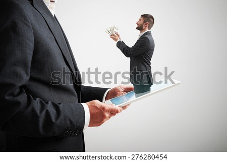 small smiley man got out of the tablet pc and offering money to the big man in formal wear over light grey background