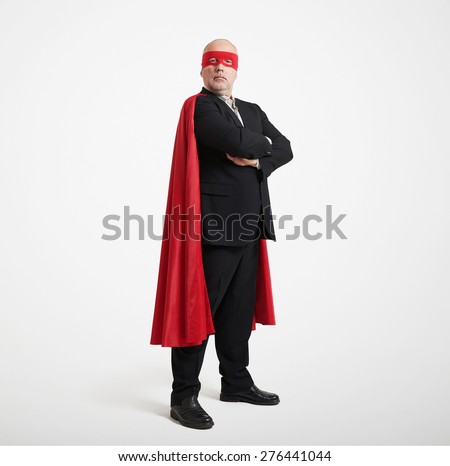 confident senior businessman wearing like super hero in red mask and cloak over light grey background