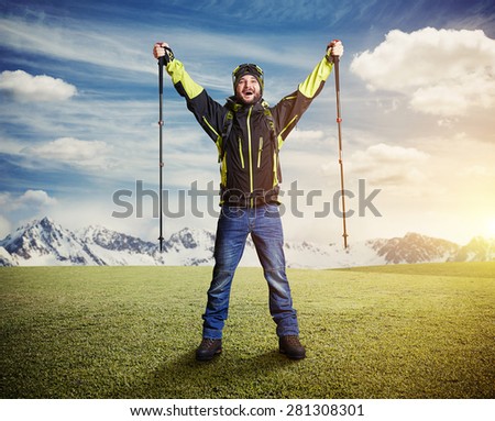 happy tourist with hiker poles raising his hands up on beautiful landscape