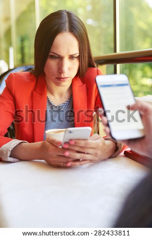 concept photo of smartphone addiction. woman and man sitting in cafe with smartphone and do not looking at each other