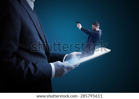 small man with gun got out of the tablet pc and aiming at the big man over dark background. cybercrime concept