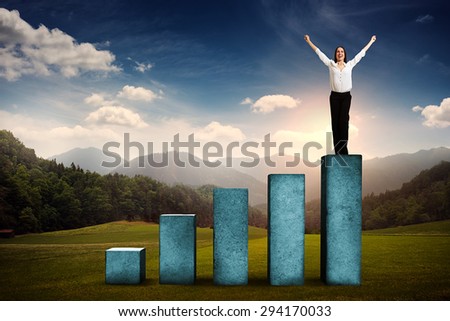 happy businesswoman winner standing on top of concrete diagram over beautiful landscape with forest, hills and sky