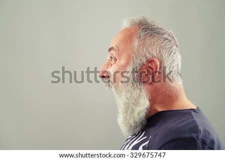 sideview portrait of screaming senior man with grey-haired beard