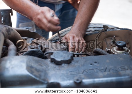 Hand with wrench. Auto mechanic in car repair