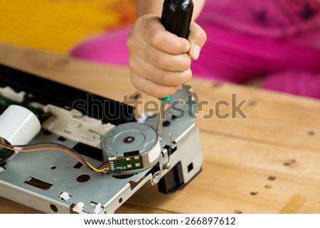 A hand holding a screwdriver is installing or repairing part of computer components