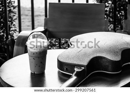 black and white Coffee and acoustic guitar on wood table