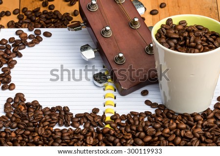 coffee beans in cup with guitar and beans on blank notebook for b