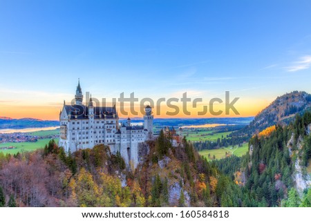 Neuschwanstein, Lovely Autumn Landscape Panorama Picture of the fairy tale castle near Munich in Bavaria, Germany with colorful trees in the morning hours