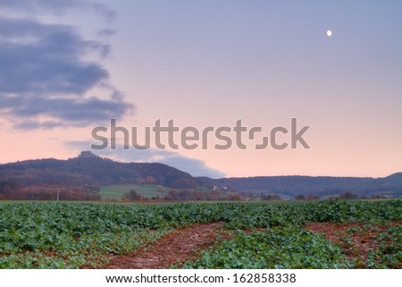 Lovely Fall Landscape Panorama Sunset Picture in Bavaria, Germany / Europe. Clouds, Fog and Blue Sky at the evening in the last glow of the sunset