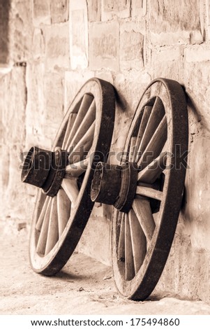 Wheel of Time. Vintage Black and White Picture of old wooden wheels on a castle in Bavaria, Germany / Europe . Still Life Picture. Stone walls.