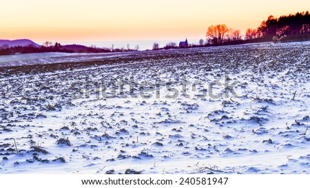 Bavarian Guegel Chapel Winter Sunset. Blue Snow and Clear Sky. Catholic Chapel Silhouette against the setting sun. Lovely winter landscape