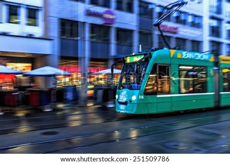 BASEL, SWITZERLAND - JANUARY 24 2015: Tram in the swiss city of Basel in the evening on a cold and snowy winter day. Evening in Switzerland. Motion Blur