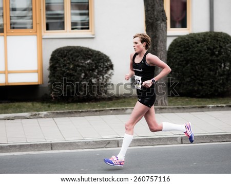 BAMBERG, GERMANY - MARCH 15 2015: Kaiserdomlauf, traditional long distance race event in the City of Bamberg in Bavaria, Germany in March 2015. Woman running