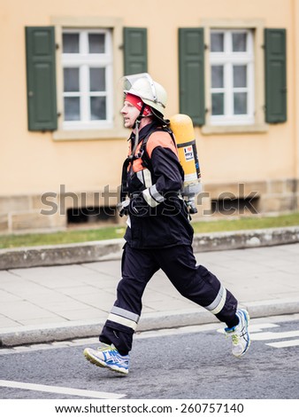 BAMBERG, GERMANY - MARCH 15 2015: Kaiserdomlauf, traditional long distance race event in the City of Bamberg in Bavaria, Germany in March 2015. Firefighter taking part